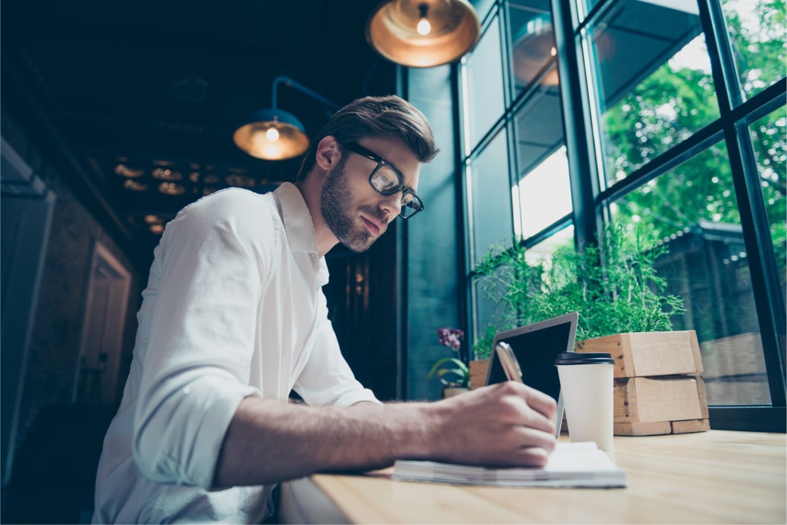 blog thumbnail: a male in white shirt writing on a piece of paper