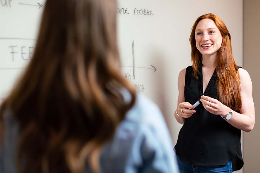 Smiling student at a whiteboard.